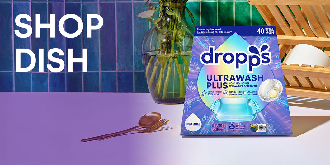 Dropps Ultrawash Plus packaging on a kitchen counter with utensils. SHOP DISH.