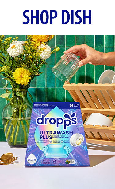 Dropps Ultrawash Plus packaging on a kitchen counter with utensils. SHOP DISH.