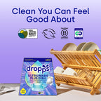 Dropps UltraWash Plus Dish packaging with a wooden dish rack and clean dishes on a light surface.