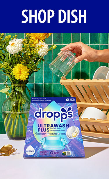 Dropps Ultrawash Plus packaging on a kitchen counter with utensils. SHOP DISH.